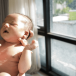 Tắm nắng cho bé gần cửa sổ vào buổi sáng